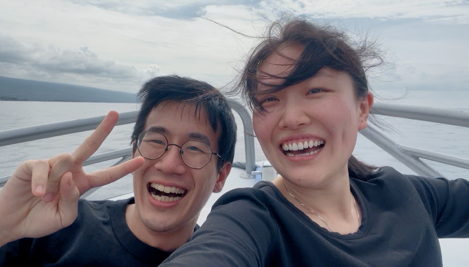 The couple laughing on a boat out on the open water in Hawaii