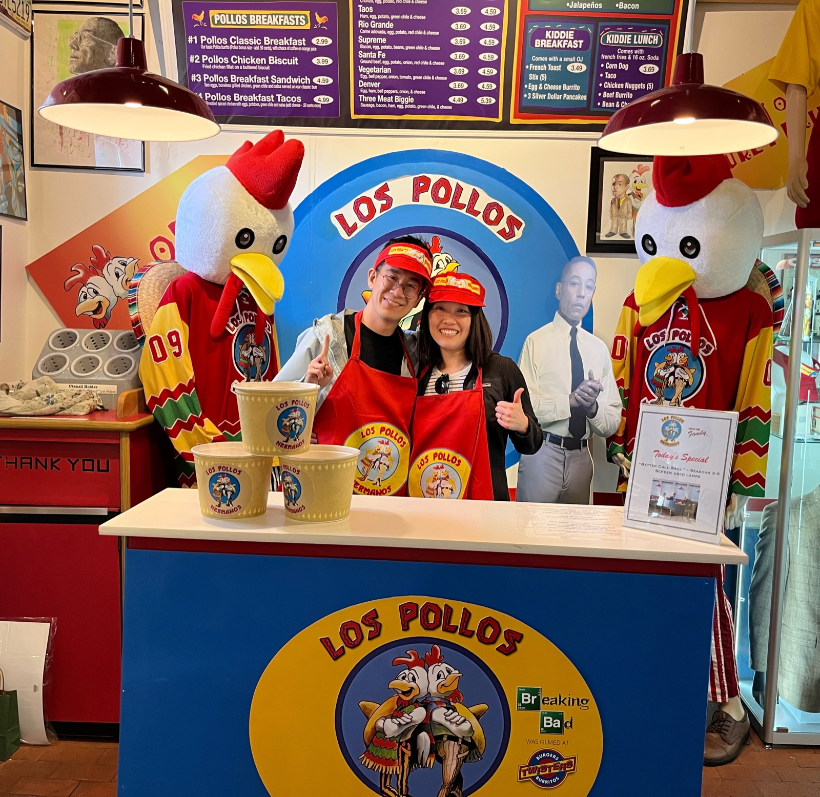 The couple posing at the Los Pollos Hermanos counter from Breaking Bad in New Mexico