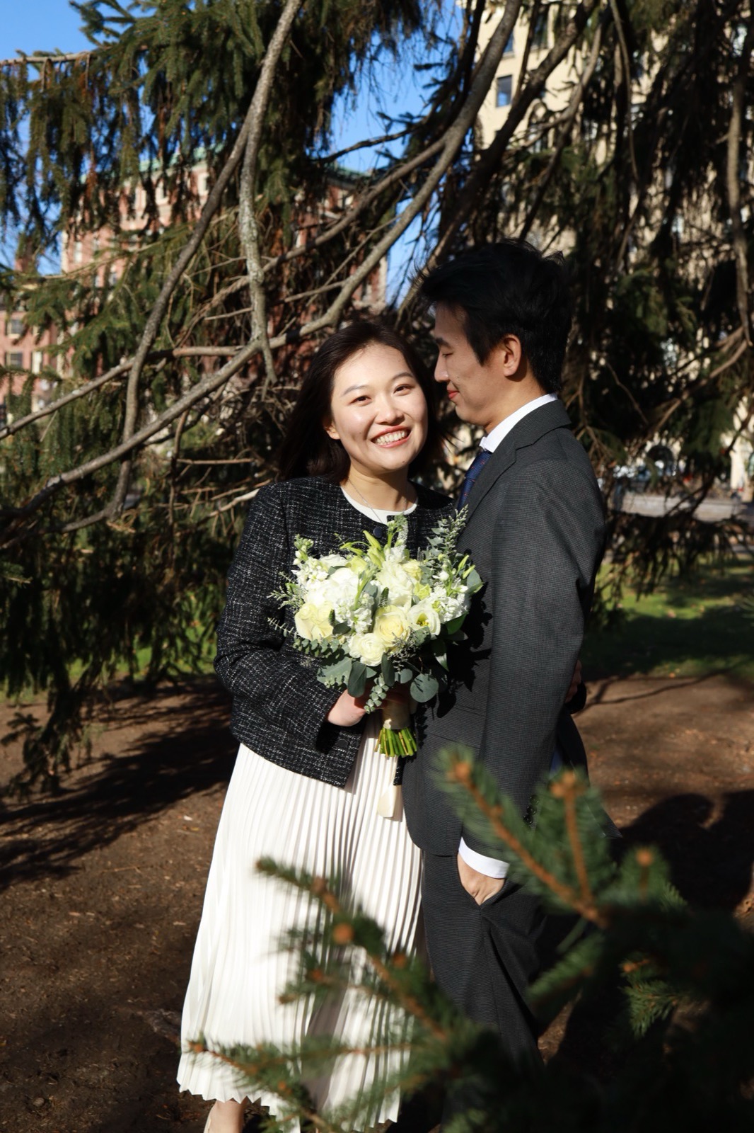 The couple on the day of the proposal, the bride holding a white bouquet in Boston Common